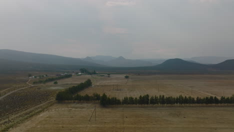 Slider-of-landscape-with-farm-and-fields-under-overcast-sky.-Mountain-ridges-in-background.-South-Africa