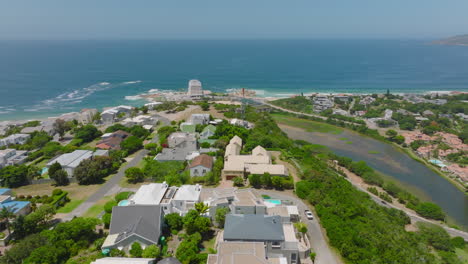 Cinematic-shot-of-town-development.-Aerial-view-of-houses-in-coastal-city.-Plettenberg-Bay,-South-Africa