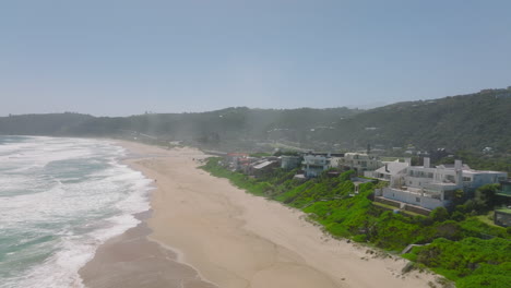 Aerial-footage-of-buildings-on-waterfront.-Houses-in-vacation-destination-with-direst-access-to-sand-beach-on-sea-coast.-South-Africa
