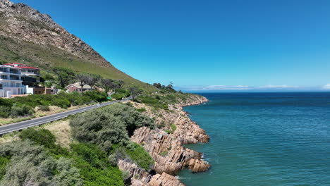 Car-driving-on-coastal-road-on-sunny-day.-Slide-and-pan-shot-of-rugged-rocky-sea-shore.-South-Africa