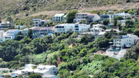 Slide-and-pan-footage-of-luxurious-residences-of-vacation-apartment-houses-on-slope-with-green-vegetation.-Tropical-summer-holiday-destination.-South-Africa