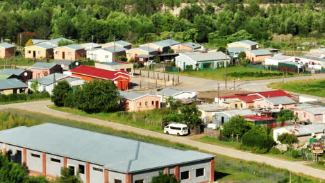 Aerial-footage-of-group-of-low-and-poor-houses-in-suburbs.-Village-surrounded-by-green-trees.-South-Africa