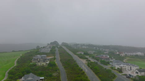 Forwards-fly-above-street-and-family-houses-around.-Misty-weather-limiting-visibility.-Port-Elisabeth,-South-Africa