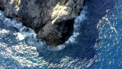 AERIAL:-Close-Up-of-Cliff-on-Tropical-Island-Mallorca,-Spain-with-ocean-and-Blue-water-in-Summer,Daylight-Vacation,-Travel,-Sunny,-Waves