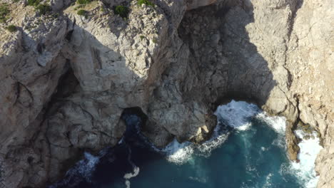 AERIAL:-Beautiful-Drone-Shot-of-Cliff-and-Blue-Water-Waves-crushing-on-Tropical-Island-Mallorca,-Spain-Vacation,-Travel,-Sunny,-Waves
