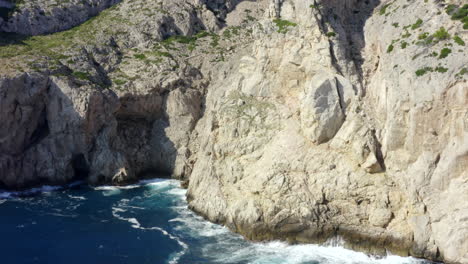 AERIAL:-Edge-of-Cliff-with-Blue-Water-Waves-crushing-on-Tropical-Island-Mallorca,-Spain-Vacation,-Travel,-Sunny,-Waves