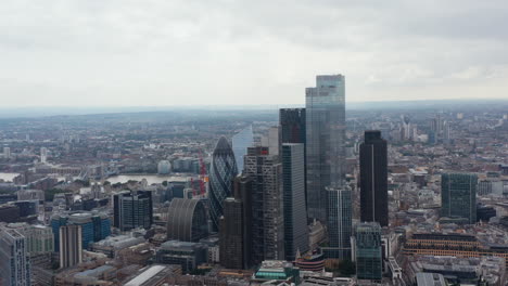 Aerial-view-of-skyscrapers-in-business-centre.-Cityscape-and-Tower-Bridge-over-Thames-river-in-background.-London,-UK
