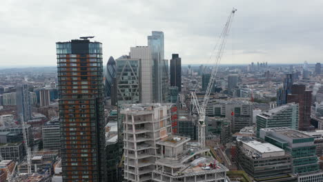 Aerial-view-of-modern-downtown-skyscrapers-in-large-city.-Crane-on-construction-site-of-new-building.-London,-UK