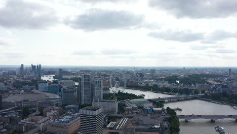 Aerial-view-of-Thames-river-winding-through-city.-Mixture-of-historic-and-modern-architecture.-Forwards-fly-against-cloudy-sky.-London,-UK