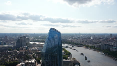 Pull-back-footage-of-upper-part-of-One-Blackfriars-tall-modern-skyscraper-with-shiny-glass-facade-standing-on-River-Thames-waterfront.-London,-UK