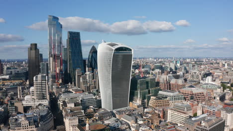 Group-of-skyscrapers-in-City-financial-district-distinctively-protruding-above-other-buildings-in-town.-Modern-glass-covered-office-towers.-London,-UK