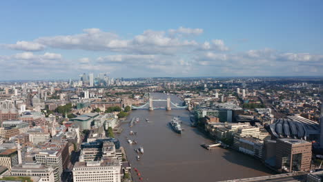 Forwards-fly-above-River-Thames.-Aerial-view-of-HMS-Belfast-museum-ship-and-famous-Tower-Bridge.-Panoramic-aerial-view-of-city.-London,-UK