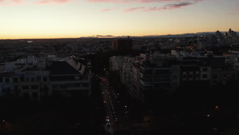 Slide-and-pan-footage-of-buildings-around-street-in-urban-neighbourhood-after-sunset.-Romantic-twilight-sky.