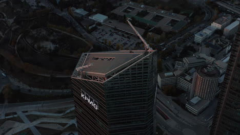 Ascending-aerial-footage-of-top-of-modern-skyscraper-in-CTBA-complex-after-sunset.-Office-building-towering-high-above-town.
