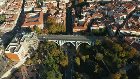 Fliegen-Sie-über-Die-Historische-Straßenbogenbrücke-Segovia-Viadukt,-Das-Das-Tal-In-Der-Stadt-überspannt.-Autos-Fahren-Auf-Der-Straße.
