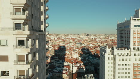 Aufsteigende-Aufnahmen-Aus-Der-Luft-Entlang-Der-Wand-Mit-Fenstern-Und-Balkonen.-Torre-De-Madrid-Historischer-Wolkenkratzer-Und-Stadtbild-Im-Hintergrund.