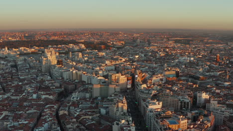 Ascending-footage-of-town-at-sunset.-Aerial-panoramic-shot-of-city-centre-with-famous-shopping-Gran-Via-street.