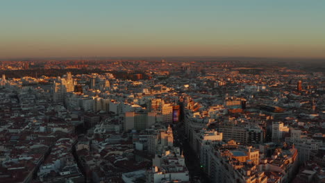 Tops-of-buildings-in-city-centre-lit-by-setting-sun.-Panoramic-elevated-footage-of-cityscape.