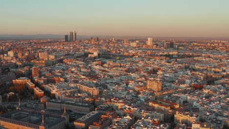 Aerial-panoramic-footage-of-cityscape-at-sunset.-Budlings-lit-by-bright-orange-light.