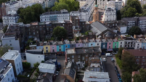 Slide-and-pan-footage-of-row-of-houses-with-colourful-facades.-Aerial-view-of-streets-of-urban-neighbourhood.-London,-UK