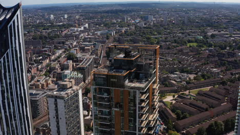 Slide-and-pan-footage-of-One-The-Elephant-skyscraper-top-part.-Aerial-view-of-platform-high-above-city.-London,-UK