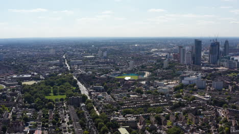 Forwards-fly-above-Kennington-urban-borough.-Aerial-panoramic-view-of-residential-houses,-The-Oval-stadium-and-group-of-skyscrapers.-London,-UK