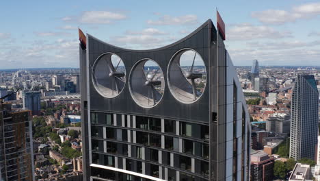 Pull-back-shot-of-top-of-Strata-skyscraper.-Modern-design-tall-apartment-building-with-three-wind-turbines-integrated-in-construction.-London,-UK
