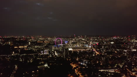 Aerial-panoramic-footage-of-large-city-at-night.-Illuminated-landmarks,-street-lights-and-traffic-from-height.-London,-UK