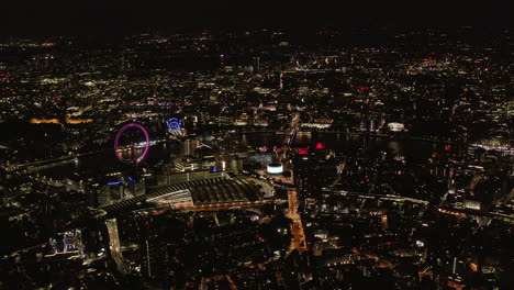 High-angle-view-of-Waterloo-train-station-and-London-Eye-at-Thames-river-bank.-Aerial-panoramic-shot-of-city-at-night.-London,-UK