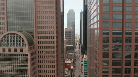 Ascending-and-tilt-down-footage-of-downtown-skyscrapers.-View-along-street-between-tall-buildings.-Dallas,-Texas,-US