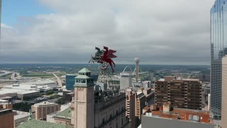 Forwards-ascending-fly-to-Pegasus-on-roof-of-Magnolia-Building.-Two-massive-red-sculptures-on-top-tall-building.-Dallas,-Texas,-US