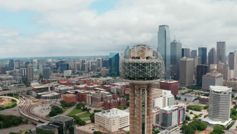 Panoramic-aerial-drone-view-flying-around-top-of-Reunion-Tower,-famous-lookout-place,-sphere-on-tall-pillar.-Skyline-with-skyscrapers-in-background.-Dallas,-Texas,-US