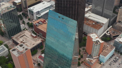 Sky-reflecting-in-tilted-glass-facade-of-tall-building.-Aerial-tilt-up-footage-of-modern-skyscraper.-Dallas,-Texas,-US