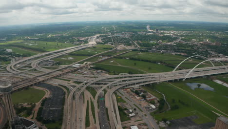 Tilt-down-reveal-of-large-and-complex-multi-lane-highway-interchange.-Multilevel-transport-construction.-Busy-road-in-rush-hours.-Dallas,-Texas,-US