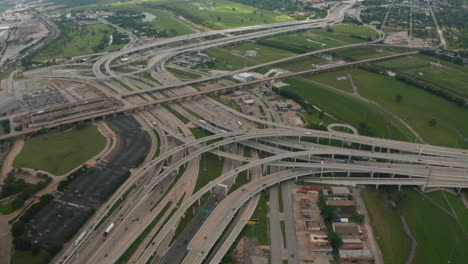 Aerial-view-of-large-and-complex-multi-lane-highway-intersection.-Cars-smoothly-driving-in-lanes-through-multilevel-transport-construction.-Drone-flying-forwards-and-tilt-down.-Dallas,-Texas,-US