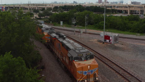 Forwards-reveal-of-long-train-standing-on-track.-Fly-above-three-powerful-diesel-engines-leading-freight-train.-Dallas,-Texas,-US