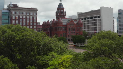 Aerial-view-of-building-in-historic-castle-style-with-tower-and-few-turrets.-Old-Red-Museum-of-Dallas-County-between-modern-multi-storey-office-blocks-downtown.-Dallas,-Texas,-US