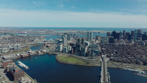 Aerial-panoramic-view-of-metropolis.-Busy-highway-around-water-dan-on-Charles-river.-residential-neighbourhoods-and-downtown-skyscrapers.-Boston,-USA