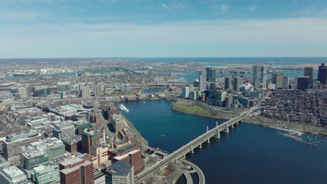 Forwards-fly-above-waterfront.-Long-bridge-over-wide-Charles-river-at-water-dam-in-city.-Urban-boroughs-on-banks.-Boston,-USA
