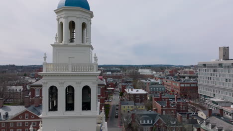 Forwards-fly-above-old-buildings-on-Harvard-University-site.-Tight-flight-around-white-tower-with-bells.-Boston,-USA