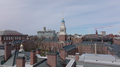 Fly-over-roofs-with-chimneys.-Historic-buildings-of-Harvard-University.-Heading-towards-tall-white-tower.-Boston,-USA
