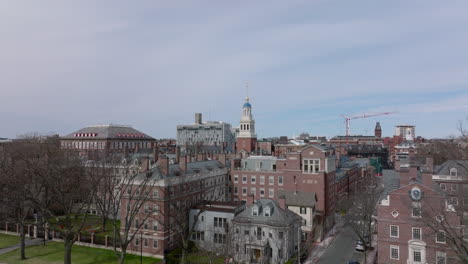 Early-spring-shot-of-red-brick-buildings-in-Harvard-University-complex.-Forwards-fly-over-street-and-row-of-leafless-trees.-Boston,-USA