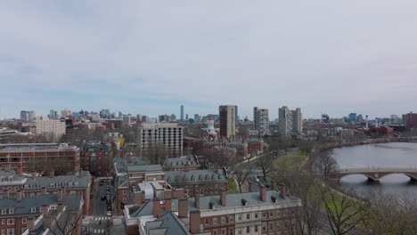 Forwards-fly-above-red-brick-buildings-in-Harvard-University-campus-at-Charles-river-waterfront.-Boston,-USA