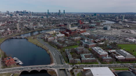 Aerial-slide-and-shot-of-Harvard-Business-School-buildings-complex.-Multilane-road-leading-between-site-and-Charles-river.-Cityscape-with-tall-buildings-in-background.-Boston,-USA