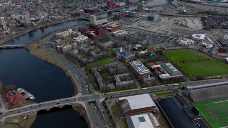 Aerial-view-of-complex-of-classical-red-brick-building-on-river-waterfront.-Harvard-Business-School-site-and-busy-road-leading-around.-Boston,-USA