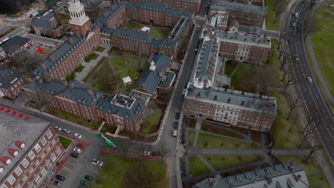 Aerial-ascending-footage-of-complex-of-historic-red-brick-buildings-in-Harvard-University-campus.-Boston,-USA