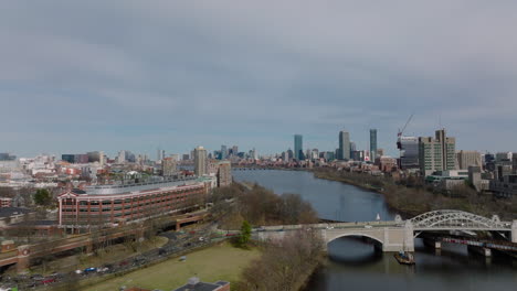 Forwards-fly-above-Boston-University-Bridge-over-Charles-river.-Aerial-view-of-cityscape-with-high-rise-business-buildings.-Boston,-USA