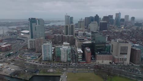 Aerial-shot-of-buildings-in-Massachusetts-General-Hospital-area-and-downtown-office-towers-in-background.-Backwards-reveal-of-busy-road-on-waterfront.-Boston,-USA