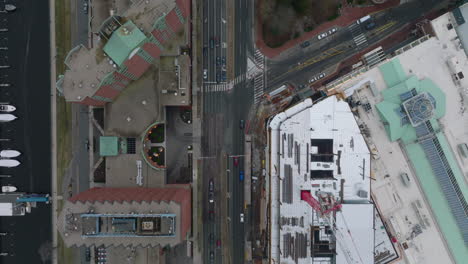 Top-down-shot-of-wide-streets-in-urban-borough.-Vehicles-driving-on-road-and-passing-through-intersection.-Boston,-USA