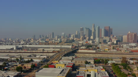 Antenne:-La-River,-Bahngleise-Mit-Der-Innenstadt-Von-Los-Angeles-Im-Hintergrund,-Sonnenlicht
